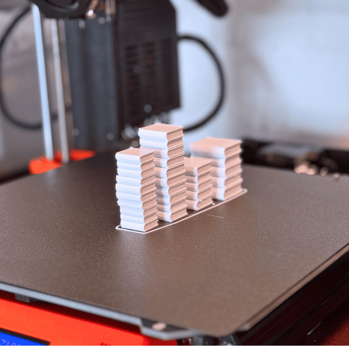 Miniatuurboekenstapels op het printbed van een 3D-printer, van Miniatures Guild