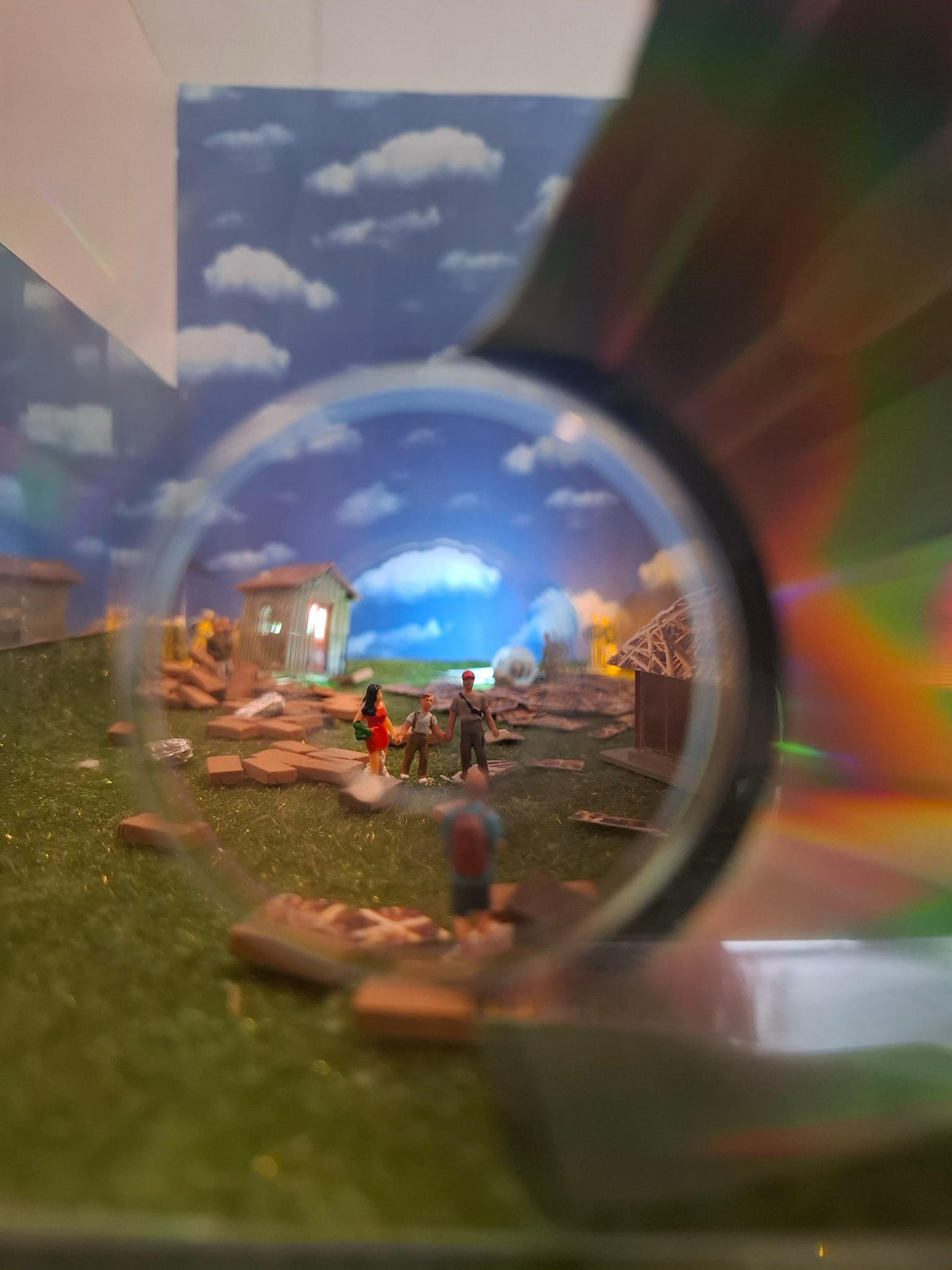 Miniatuurwereld met figuurtjes en een wolkenlucht, gefotografeerd door een glazen lens, tijdens de 3D Storytelling workshop van Miniatures Guild in Utrecht