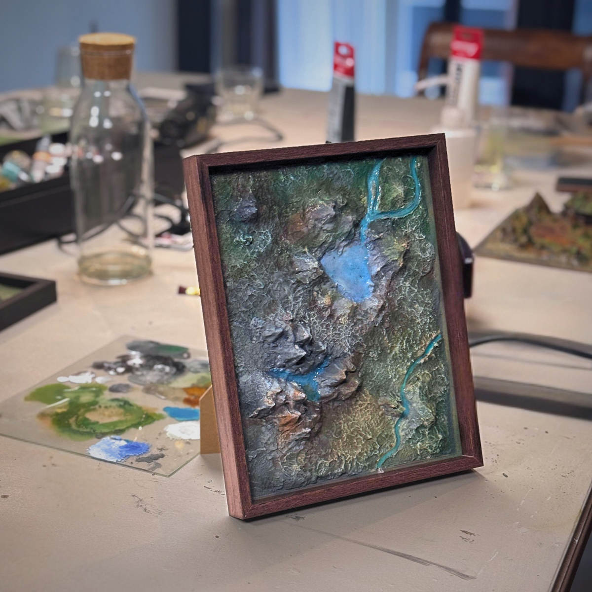Ingelijst miniatuurlandschap in reliëf met water en groen, gemaakt tijdens de Miniature Landscape workshop van Miniatures Guild in Utrecht